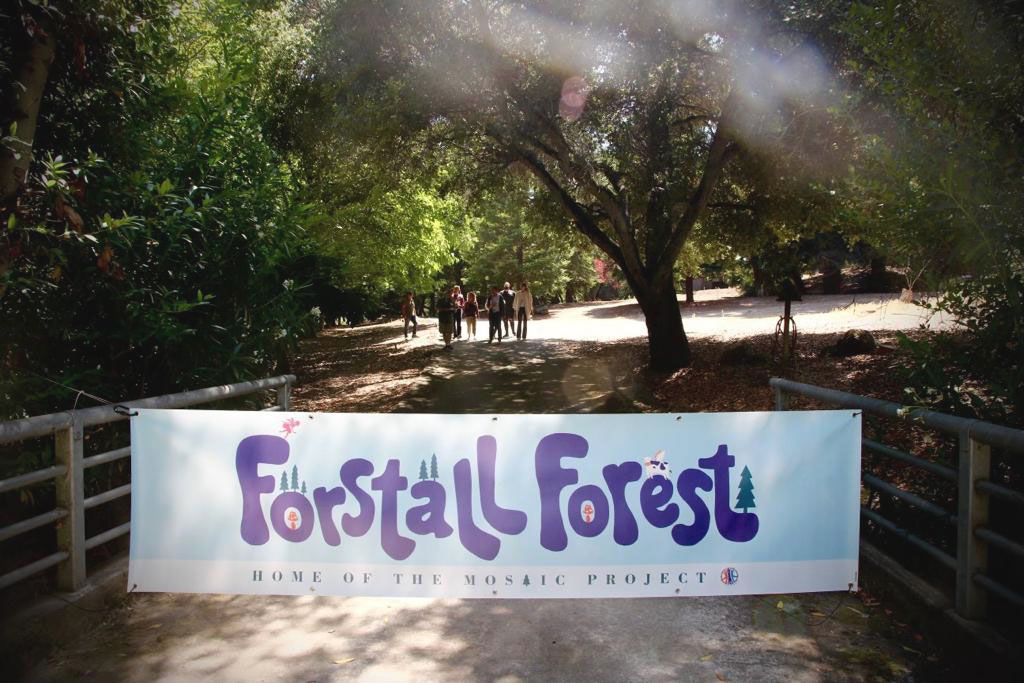 Trees and bridge with banner: Forstall Forest